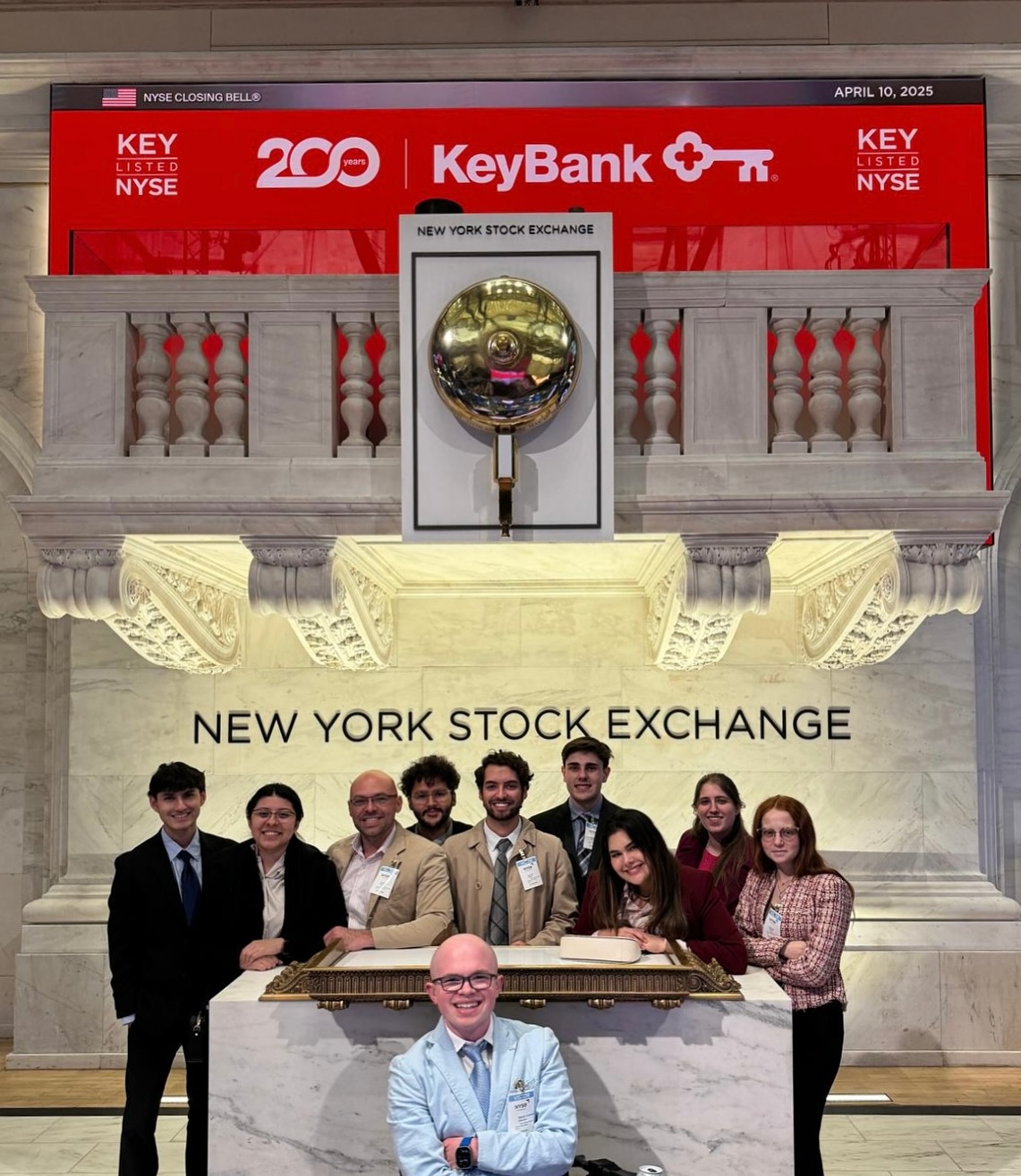 The FAU group gathered at the New York Stock Exchange closing-bell podium under a KeyBank closing bell banner dated April 10, 2025, with Ryleigh Newman in front.