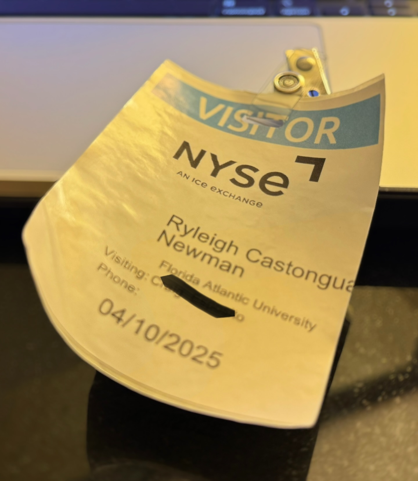 A New York Stock Exchange visitor badge reading 'Ryleigh Castonguay Newman, Florida Atlantic University, 04/10/2025.'