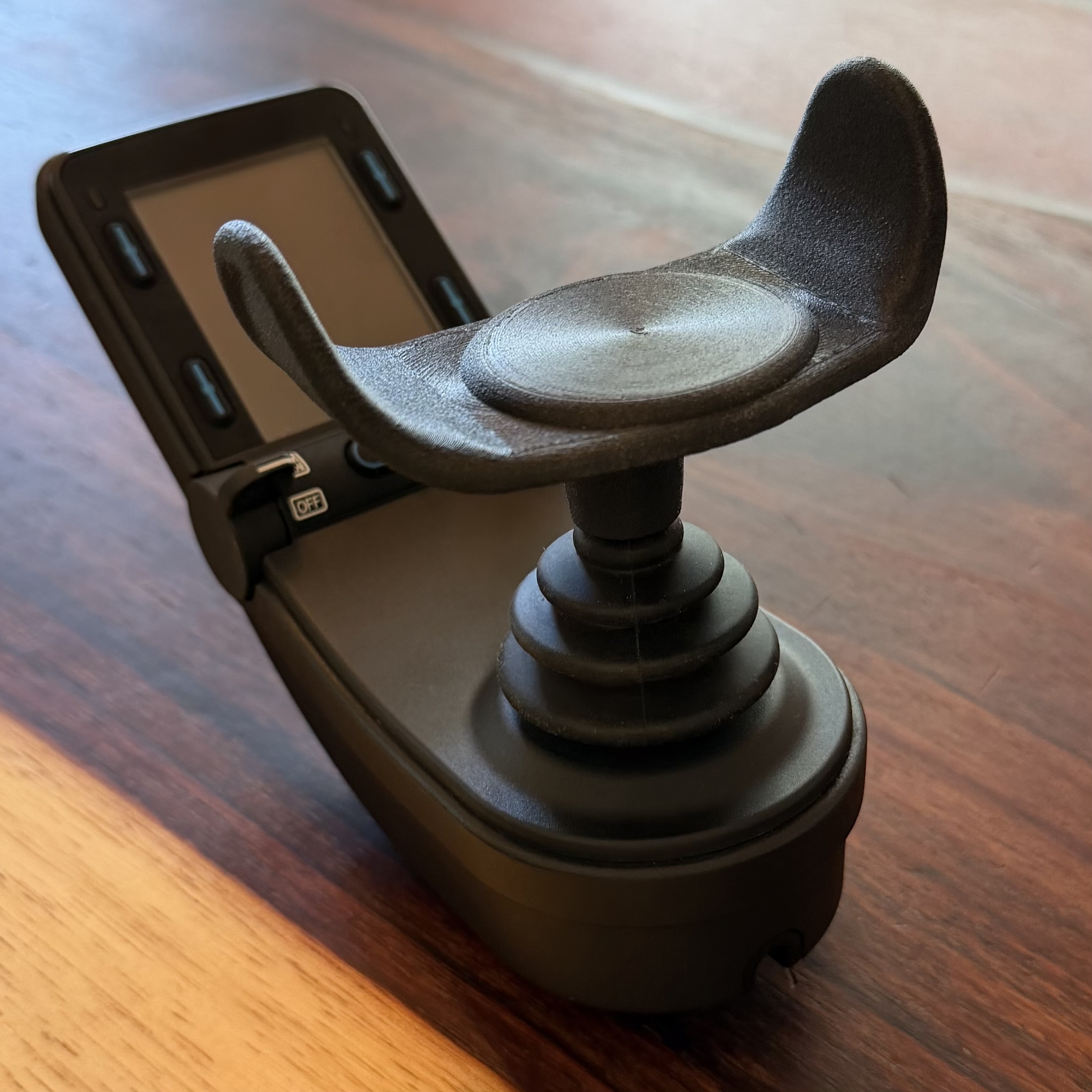 The Rockstar Health U-1 joystick topper installed on a power wheelchair controller.